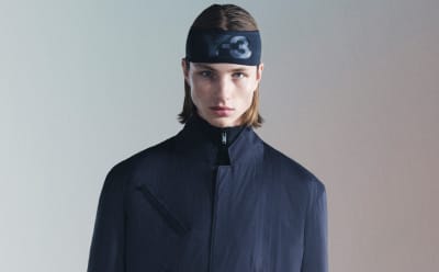 A man wearing a black adidas Y-3 headband and a navy jacket stares down the camera.