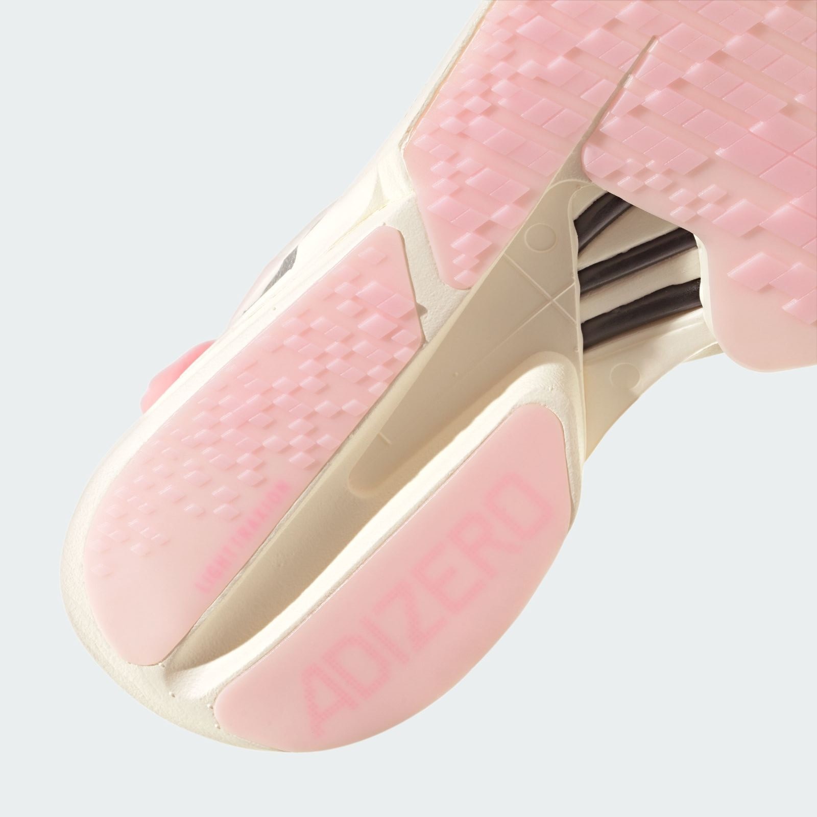 The image shows a close-up view of a pair of pink and white athletic shoes with a distinctive sole design.