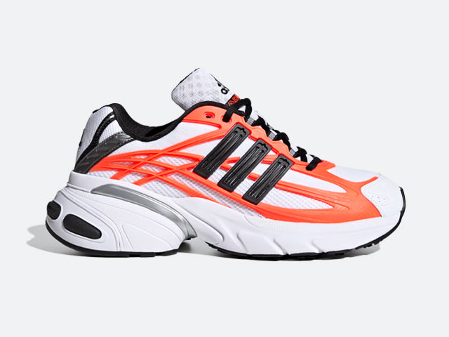 Para tętniących życiem pomarańczowo-białych sneakerów z czarnymi akcentami na zwykłym, białym tle.