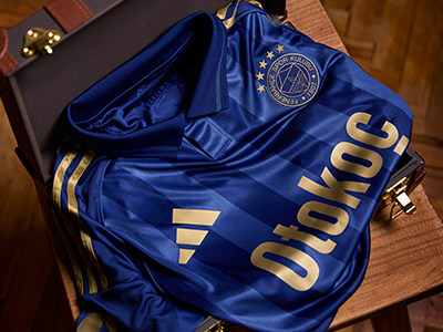 A blue and gold sports bag with the word "Dukla" prominently displayed on it, sitting on a wooden surface.