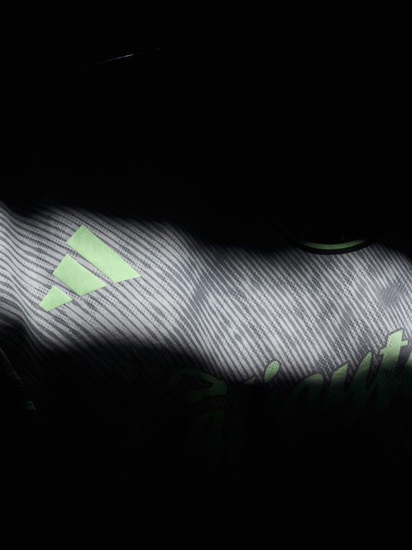 The image depicts a dark, abstract background with wavy, striped patterns in shades of gray and green, creating a sense of depth and movement.