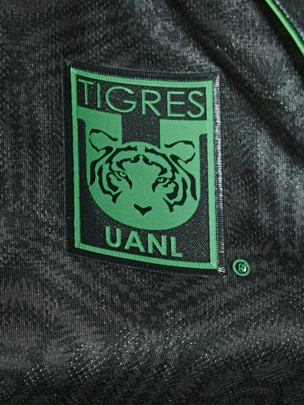 The image shows a green and black logo patch featuring a tiger's head, with the text "TIGRES UANL" prominently displayed.