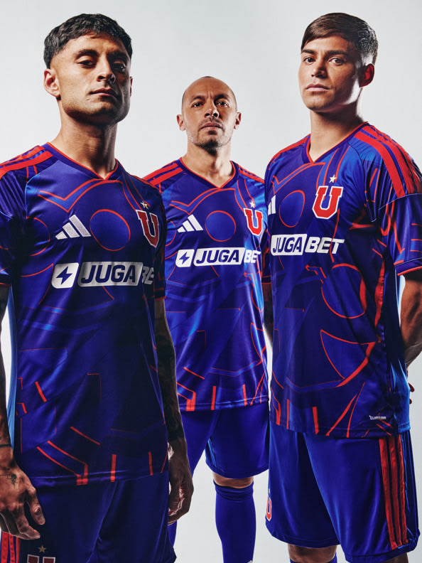 Three men wearing the same purple and red soccer uniforms, standing together against a plain white background.
