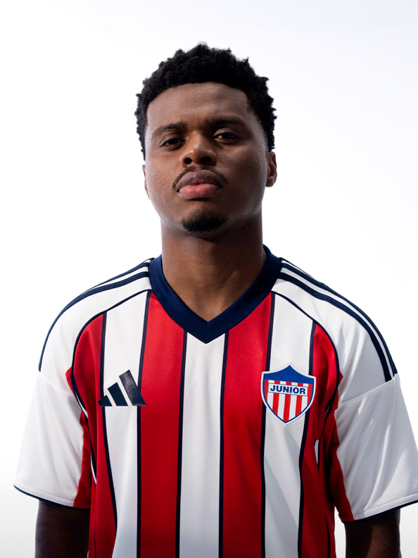 A young man wearing a red, white, and blue striped jersey stands against a plain white background.