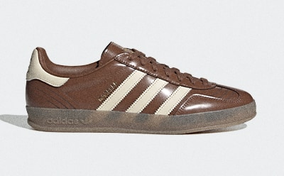 A pair of brown and beige Adidas sneakers with a textured leather upper and a thick, gum-colored sole.