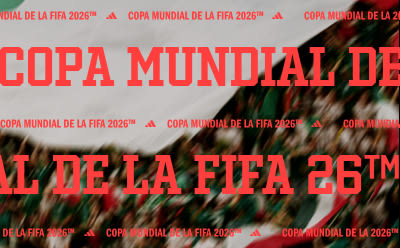 The image shows a large red banner with the text "COPA MUNDIAL DE LA FIFA 2026" prominently displayed, indicating the upcoming 2026 FIFA World Cup. The background appears to be a crowd of people, likely spectators or fans, creating a lively and energetic atmosphere.