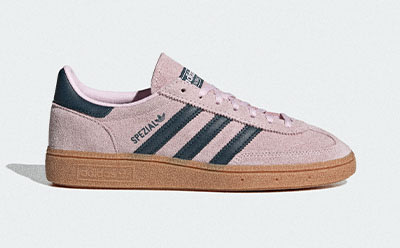 A pair of pink and black Adidas Samba sneakers with a gum sole, set against a plain white background.