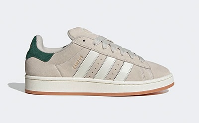 A pair of beige and green sneakers with a gum sole, set against a plain background.