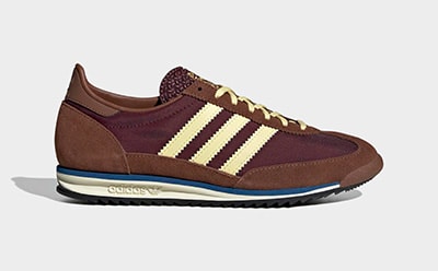 A pair of burgundy and tan sneakers with a retro athletic design, set against a plain white background.