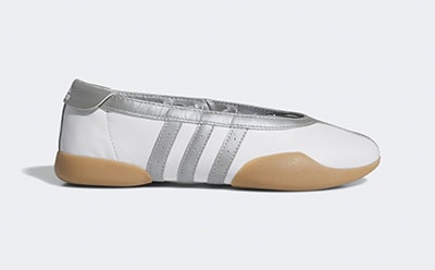 A silver and white athletic shoe with a gum sole is shown against a plain background.