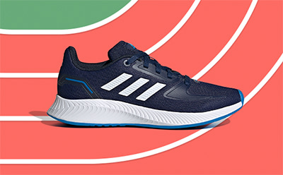 A navy blue and white athletic shoe sits on a vibrant red and green running track background.