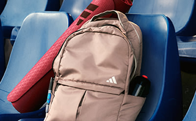 An adidas backpack on a bleacher seat.