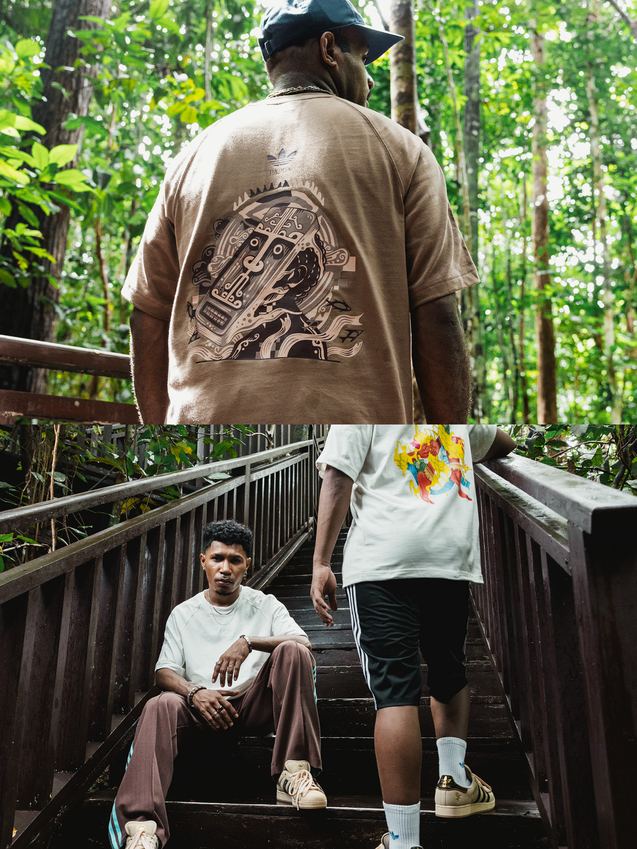 A man wearing a khaki shirt with a graphic design on the back stands on a wooden bridge, while another person sits on the steps below.