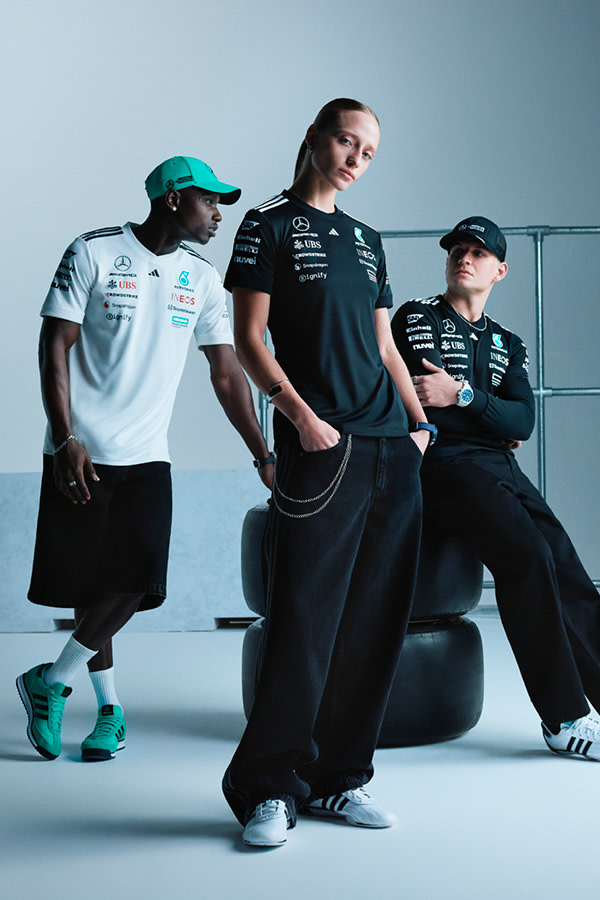 The image depicts three individuals wearing athletic clothing and posing in a studio setting with a plain background.