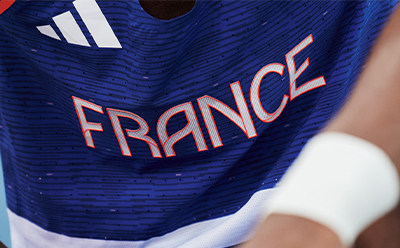 L'image montre un maillot bleu et blanc avec le mot "FRANCE" en lettres rouges.