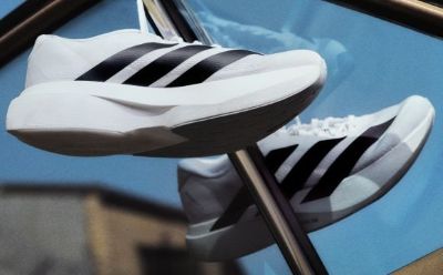 A pair of white and black athletic shoes with distinctive stripes against a vibrant blue background.
