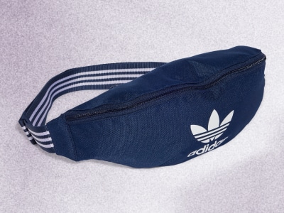 Een marineblauwe adidas heuptas met het iconische adidas logo prominent tegen een effen, lichtgekleurde achtergrond.