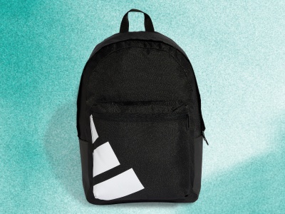 En sort rygsæk med et enkelt design står i kontrast til en livlig turkis baggrund.