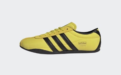 Une chaussure de sport jaune et noir ornée d'un logo adidas bien visible sur le côté.