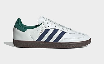 A pair of white and green Adidas Samba sneakers with navy blue stripes on a plain white background.