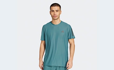 The image shows a young man wearing a teal-colored t-shirt against a plain white background.