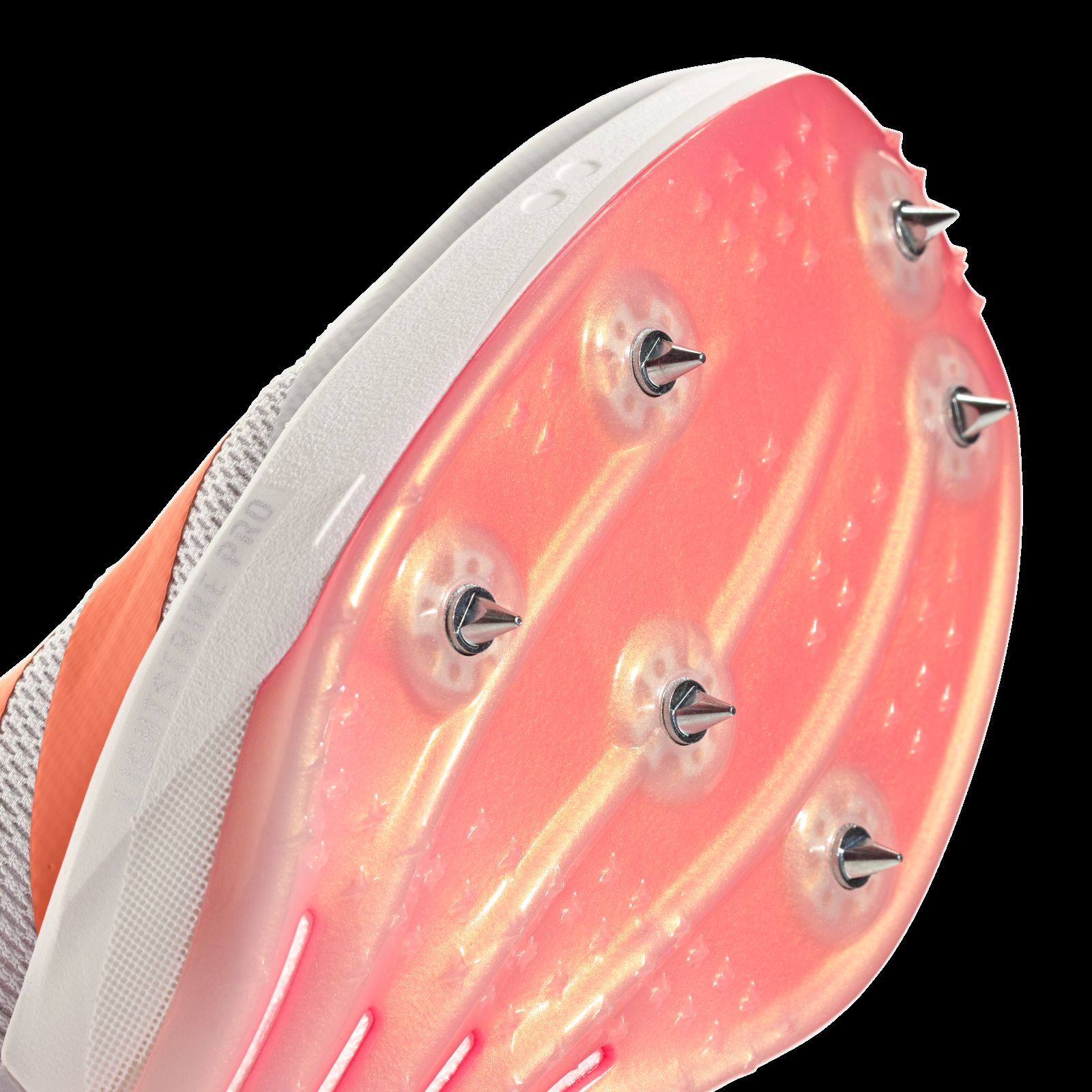 A close-up view of a bright orange and white sports shoe sole with visible studs or cleats on a dark background.