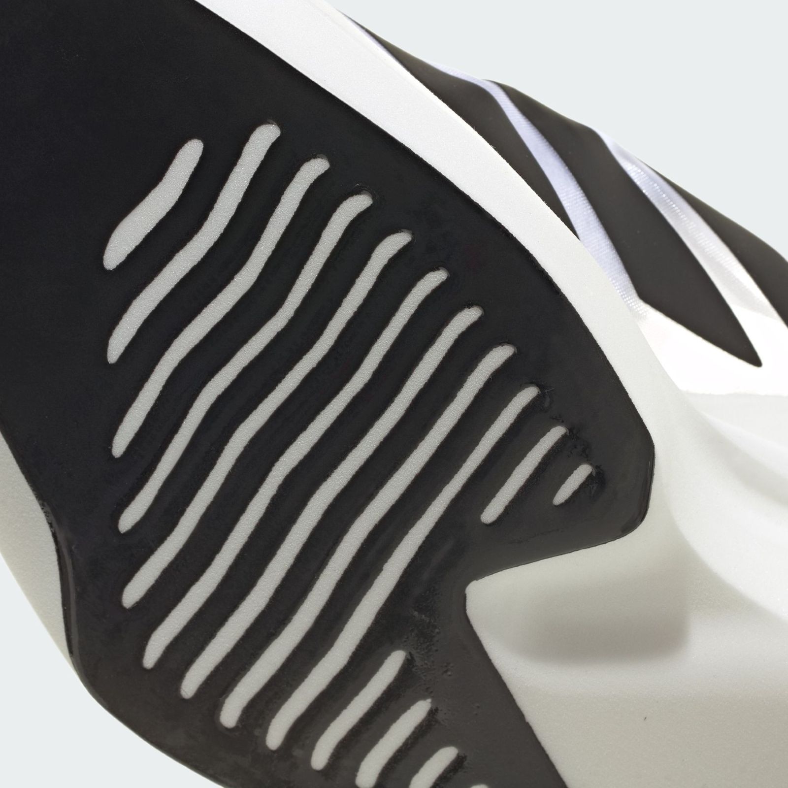 A black and white abstract sculpture with sharp, angular shapes and textured surfaces, set against a plain background.