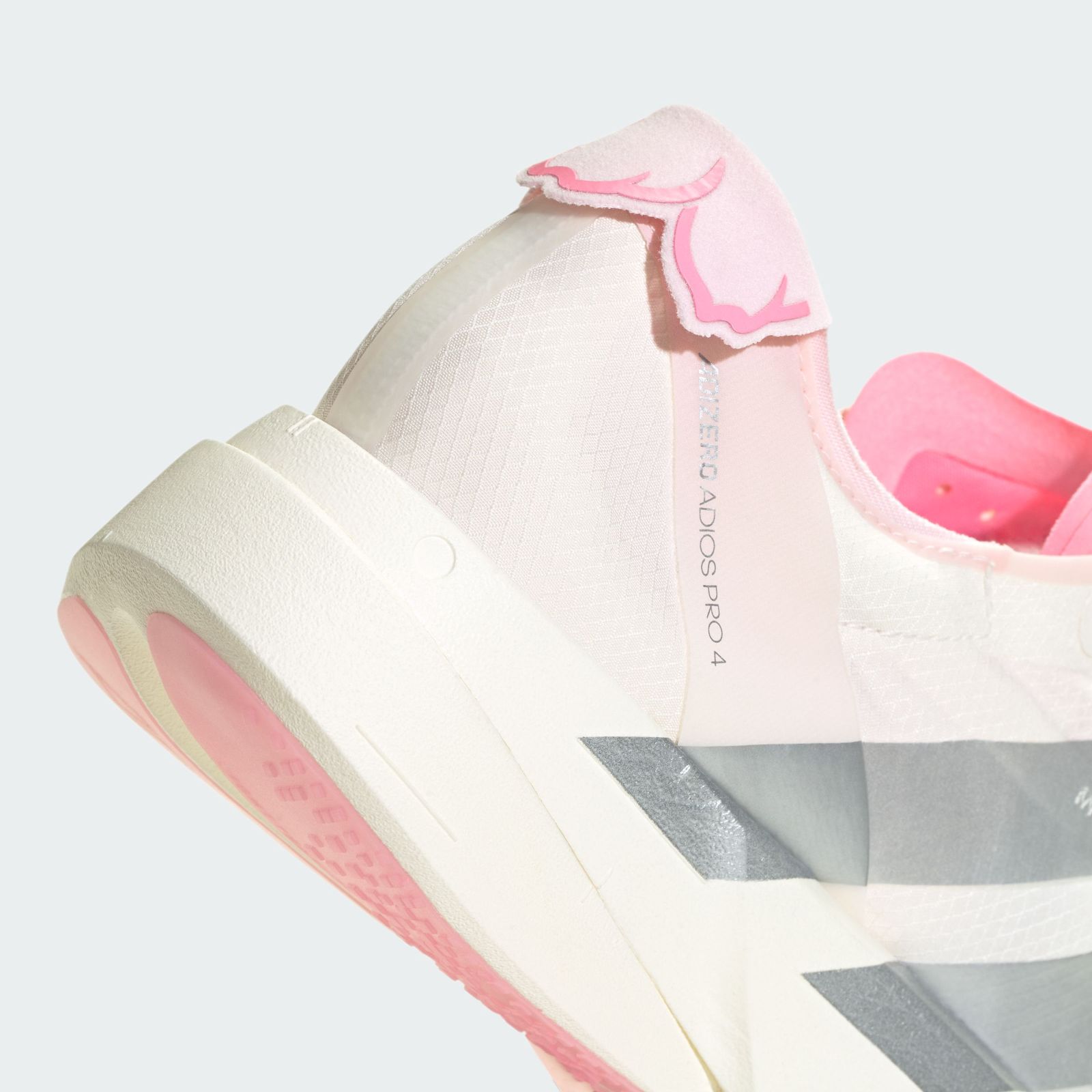 A pair of white and pink athletic shoes with distinctive stripes against a plain white background.