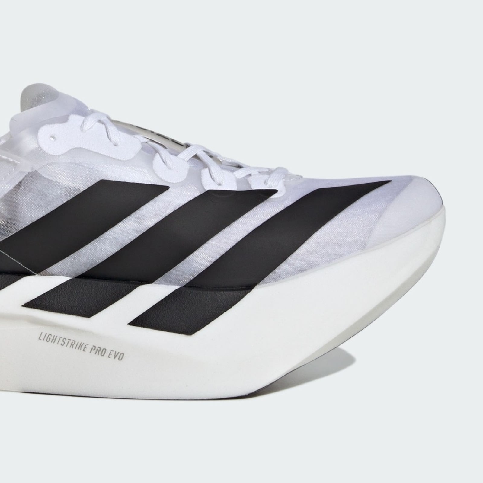 The image shows a close-up view of a white and black athletic shoe with distinctive stripes and a sleek, modern design.