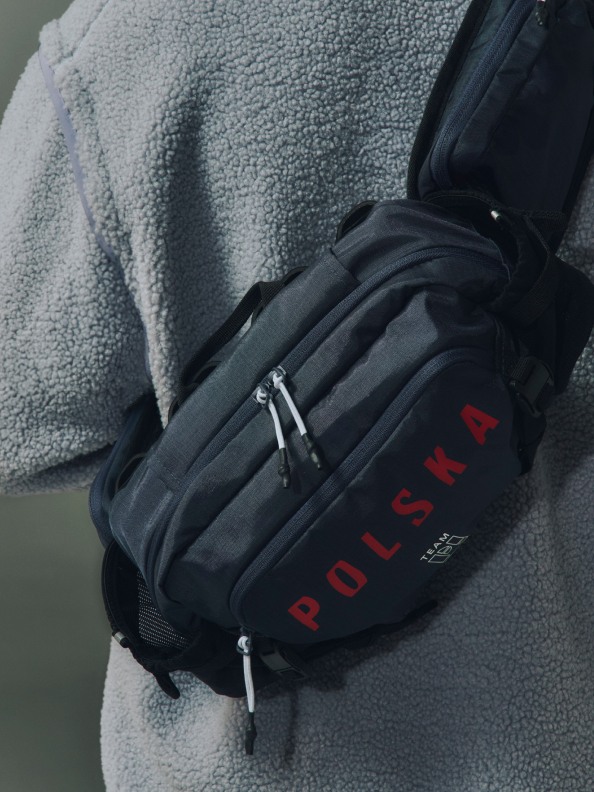 Czarno-szary plecak z nadrukowanym napisem "POLSKA" na miękkiej, szarej powierzchni materiału.