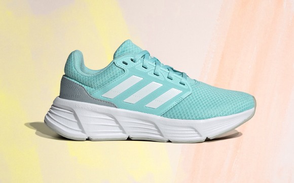 A vibrant, teal-colored athletic shoe with a thick, white sole stands out against a soft, pastel-colored background.