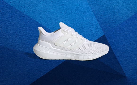 A white athletic shoe with a thick sole sits on a vibrant blue background, creating a striking visual contrast.