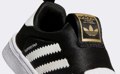 Ein schwarz-weißer adidas Sneaker mit dem legendären 3-Streifen Logo an der Seite.