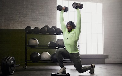 Male lifting weights wearing the adidas strength collection