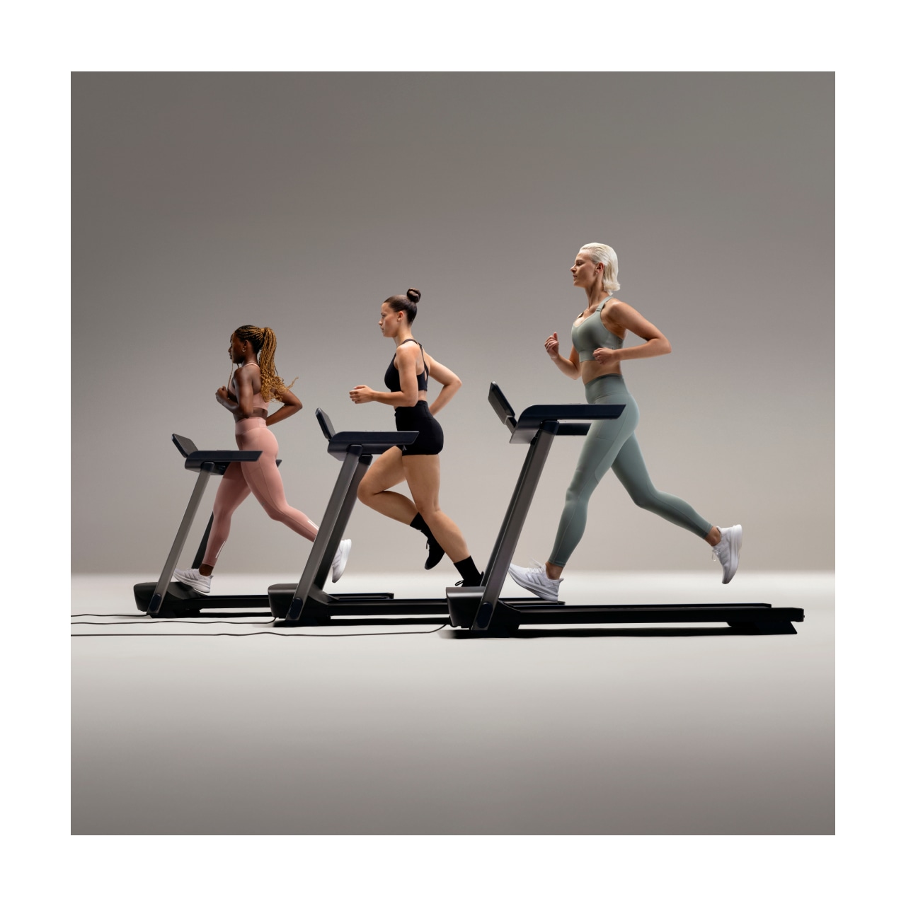 Three women wearing FASTIMPACT gear run on treadmill.