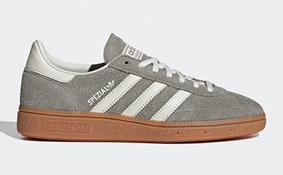 A pair of gray and white Adidas Samba sneakers with a gum sole, set against a plain white background.