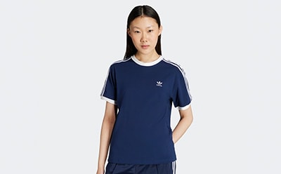 A young woman wearing a navy blue and white sports jersey stands against a plain white background.