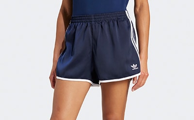 The image shows a pair of navy blue athletic shorts with white stripes on the sides, worn by a person's lower body.