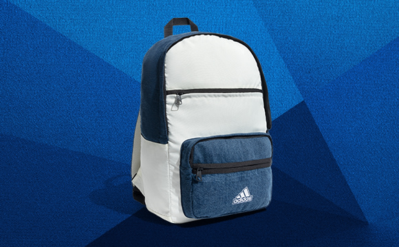 A white and gray Adidas backpack against a vibrant blue geometric background.