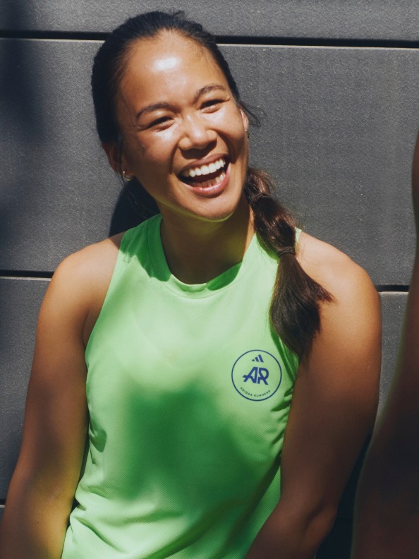 An adidas Runners member wearing a green tank from the adidas Runners collection. 