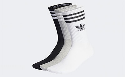 A pair of white and black striped Adidas socks against a plain white background.