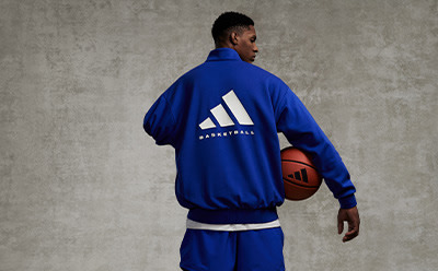 A man and woman standing beside each other in sleeveless adidas Basketball shirts