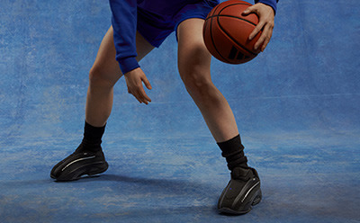 A close-up view of red high-top basketball shoes on a hardwood court.