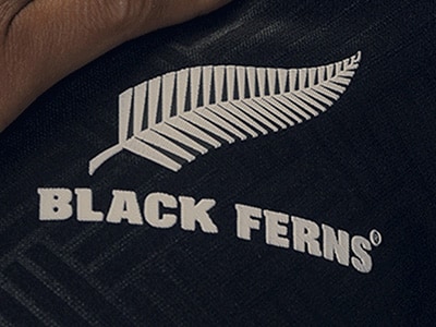 The image shows a black t-shirt with the text "BLACK FERNS" and a white fern symbol, which appears to be the logo or emblem of a sports team or organization.