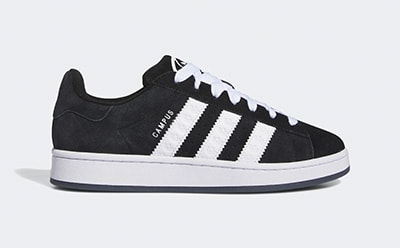 A black and white sneaker with a platform sole and lace-up design is displayed against a plain background.
