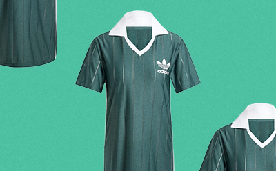 Een zwart-wit sportshirt met het adidas logo schittert tegen een levendige groene achtergrond.