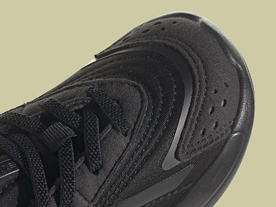Primer plano de zapatilla deportiva negra con un empeine texturizada y un prominente logotipo de Nike en el lateral.