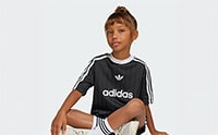A young person wearing an Adidas sports jersey is standing against a plain white background.