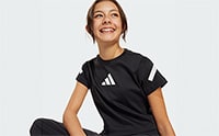 A smiling young person wearing a black Adidas sports jersey stands against a plain white background.