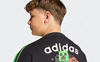 The image shows the back view of a person wearing a black Adidas shirt with the Adidas logo and a green accent.